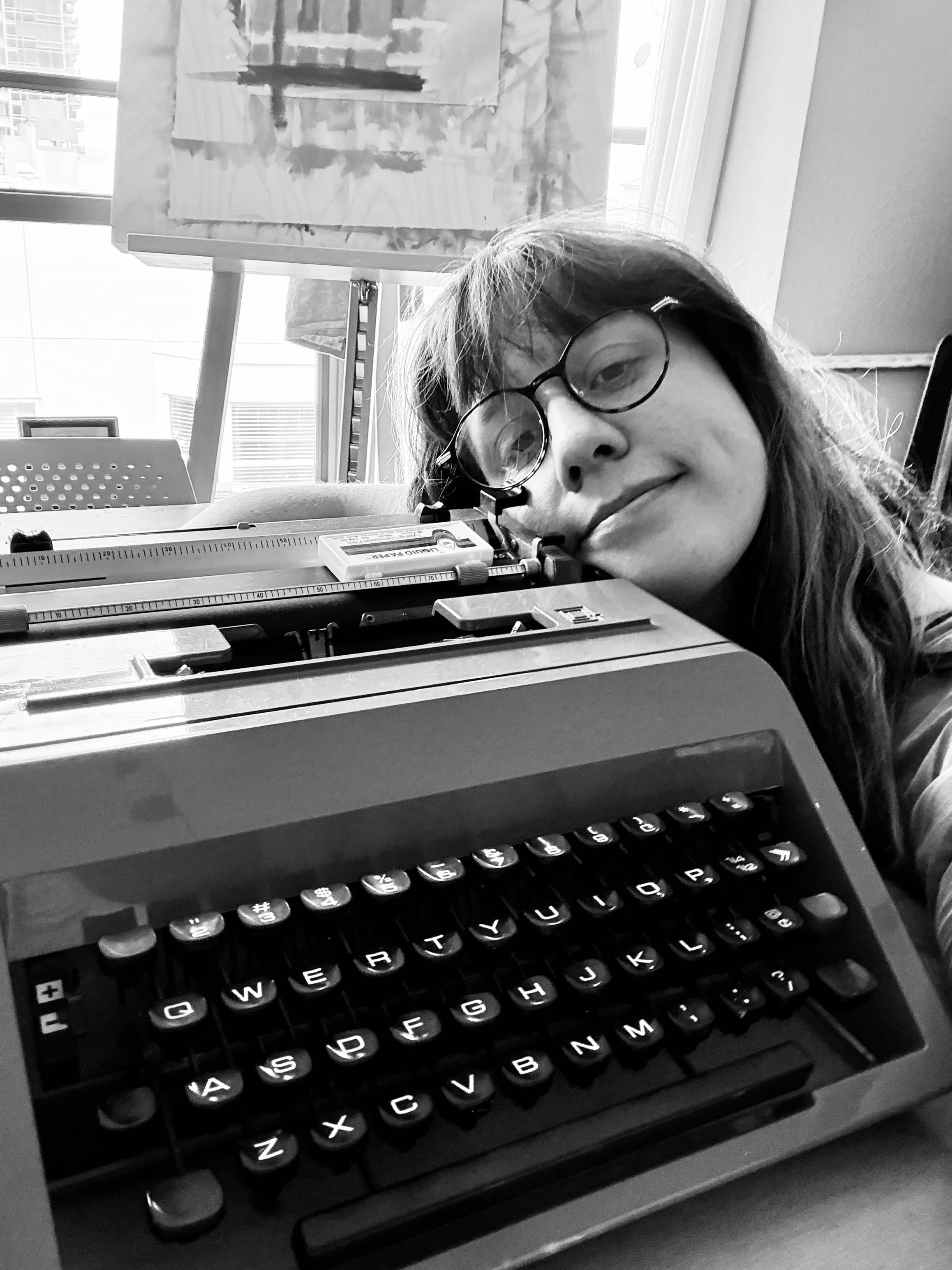 Jojo resting her head beside a restored vintage typewriter
