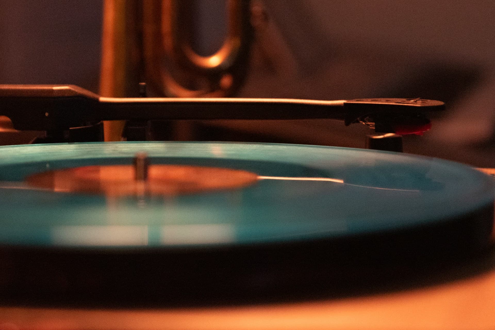 Close up of a vinyl record spinning on a turntable, warm light