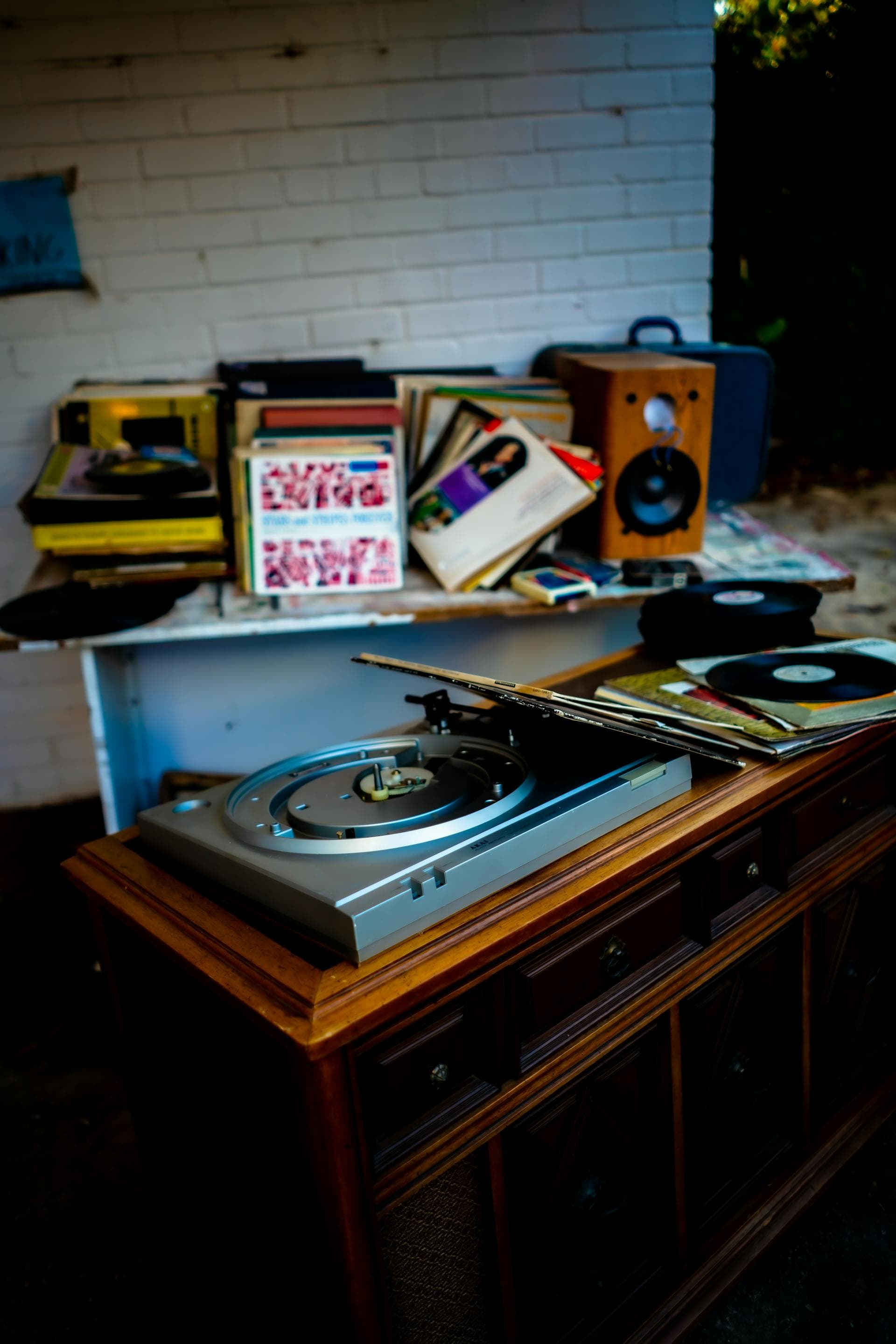 A turntable surrounded by vinyl records and a pair of bookshelf speakers